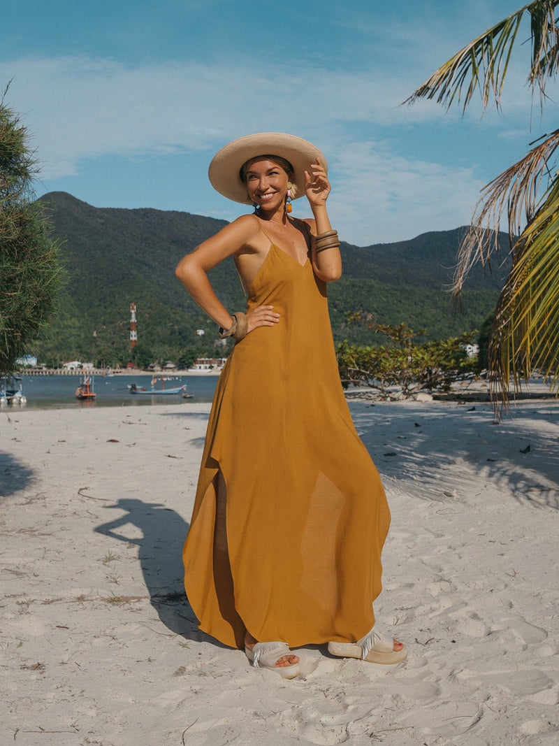 A woman in a big hat with a handbag and a long dress poses on the island of  Mauritius. a beautiful Stock Photo by Lobachad